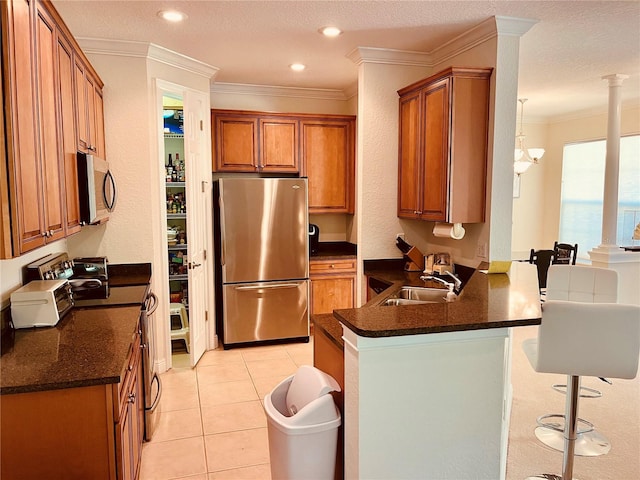 184 Banyan Bay Dr, Saint Petersburg, FL 33705 - kitchen featuring stainless steel appliances, a sink, brown cabinets, crown molding, and a peninsula