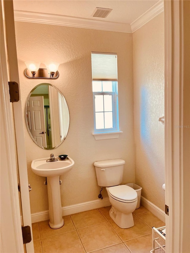 184 Banyan Bay Dr, Saint Petersburg, FL 33705 - bathroom featuring crown molding, toilet, tile patterned floors, and baseboards