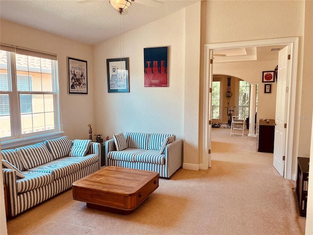184 Banyan Bay Dr, Saint Petersburg, FL 33705 - living area featuring arched walkways, light colored carpet, ceiling fan, baseboards, and lofted ceiling