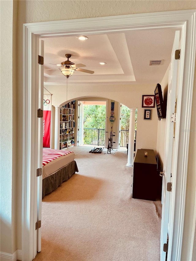 184 Banyan Bay Dr, Saint Petersburg, FL 33705 - carpeted bedroom featuring decorative columns, arched walkways, a tray ceiling, and access to exterior