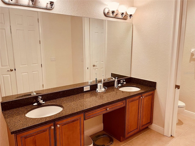 184 Banyan Bay Dr, Saint Petersburg, FL 33705 - full bath featuring tile patterned flooring, double vanity, toilet, a textured wall, and a chandelier