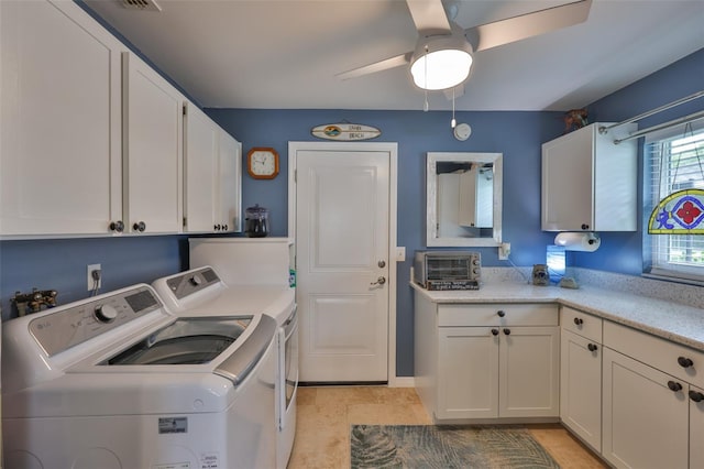 laundry room featuring washing machine and clothes dryer, cabinet space, and a ceiling fan