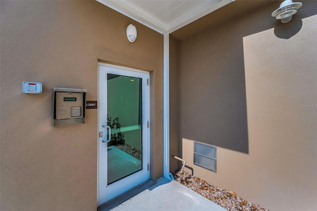 doorway to property featuring stucco siding