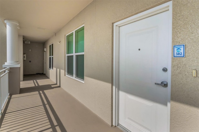 doorway to property with stucco siding and a balcony