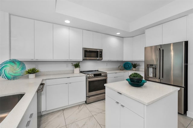 kitchen featuring appliances with stainless steel finishes, light marble finish floors, recessed lighting, a sink, and white cabinetry