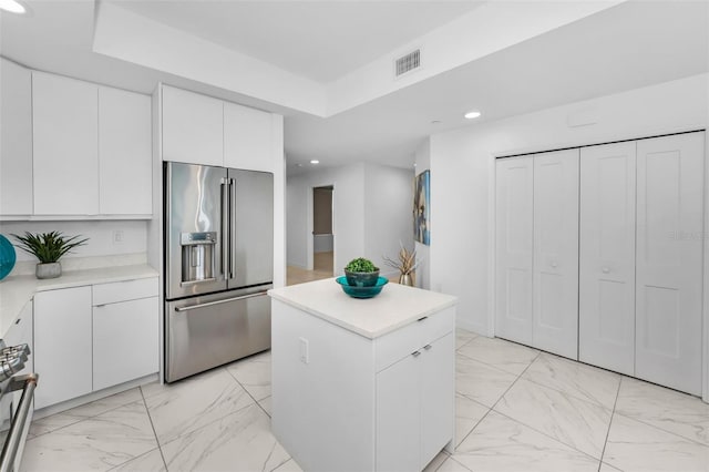 kitchen with appliances with stainless steel finishes, light marble finish floors, light countertops, recessed lighting, and white cabinets