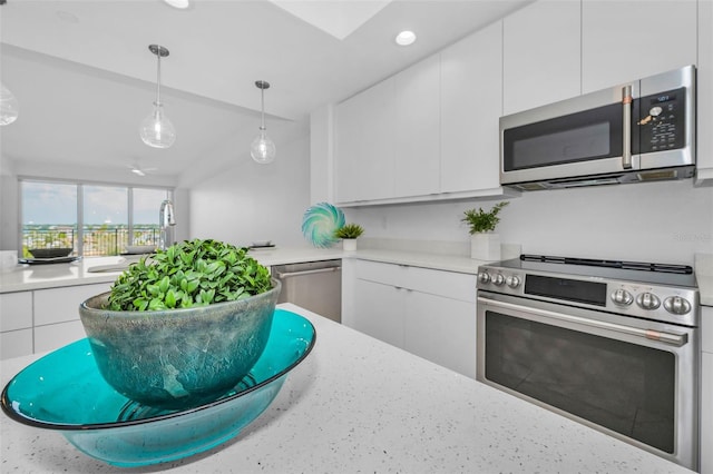 kitchen featuring stainless steel appliances, a sink, white cabinetry, light countertops, and pendant lighting