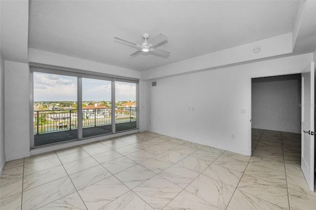 empty room featuring light marble finish flooring, ceiling fan, and baseboards