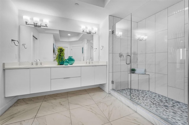 full bath with a shower stall, double vanity, marble finish flooring, and a raised ceiling