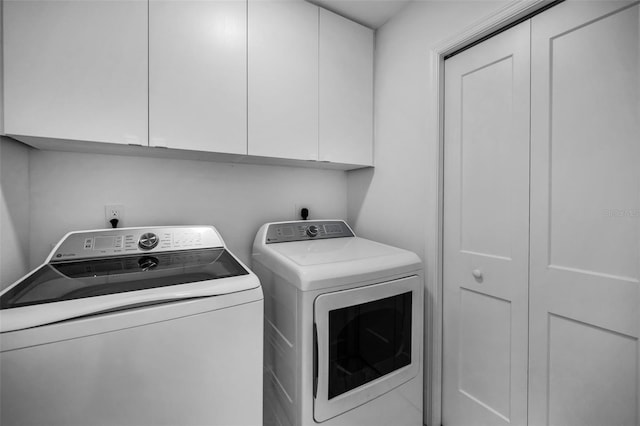 washroom featuring washing machine and clothes dryer and cabinet space