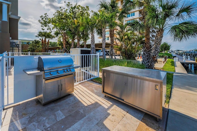 view of patio / terrace with grilling area, fence, and a hot tub