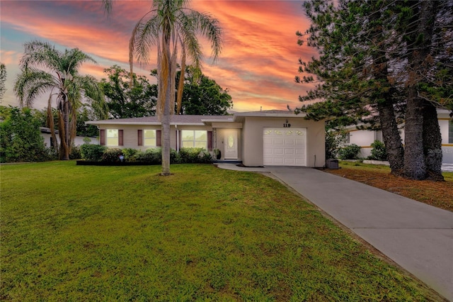 119 N Hillcrest Ave, Clearwater, FL 33755 - view of front of home with concrete driveway, a garage, a lawn, and stucco siding