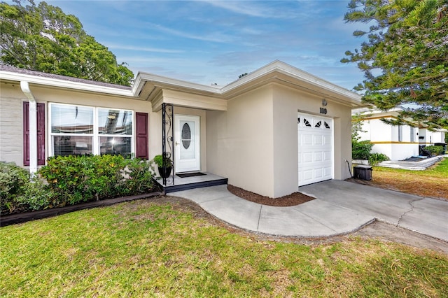 119 N Hillcrest Ave, Clearwater, FL 33755 - ranch-style house with a garage, stucco siding, a front yard, and driveway