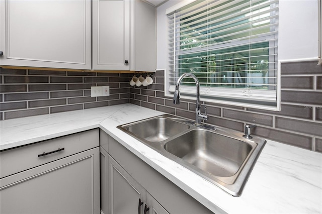 119 N Hillcrest Ave, Clearwater, FL 33755 - kitchen with a sink, decorative backsplash, gray cabinets, and light stone countertops