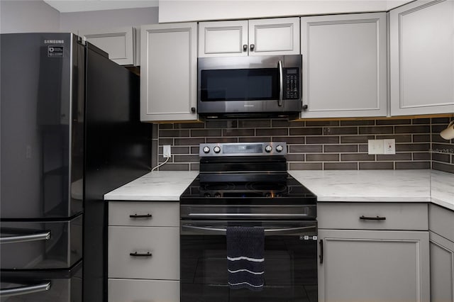 119 N Hillcrest Ave, Clearwater, FL 33755 - kitchen with appliances with stainless steel finishes, decorative backsplash, light stone countertops, and gray cabinetry