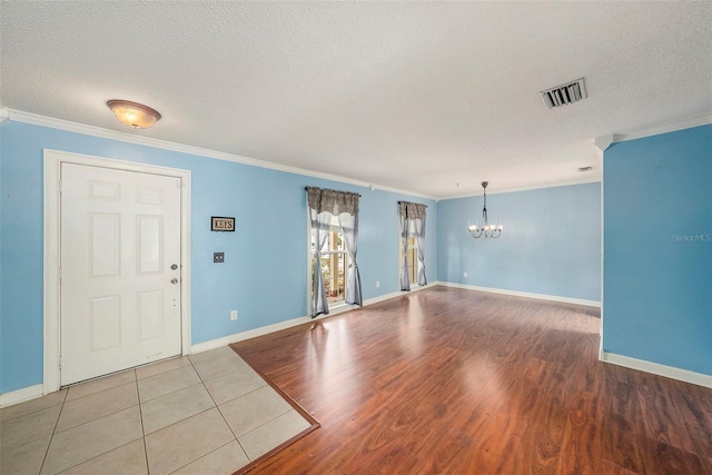 16201 Country Crossing Dr, Tampa, FL 33624 - unfurnished room with a chandelier, ornamental molding, wood finished floors, a textured ceiling, and baseboards