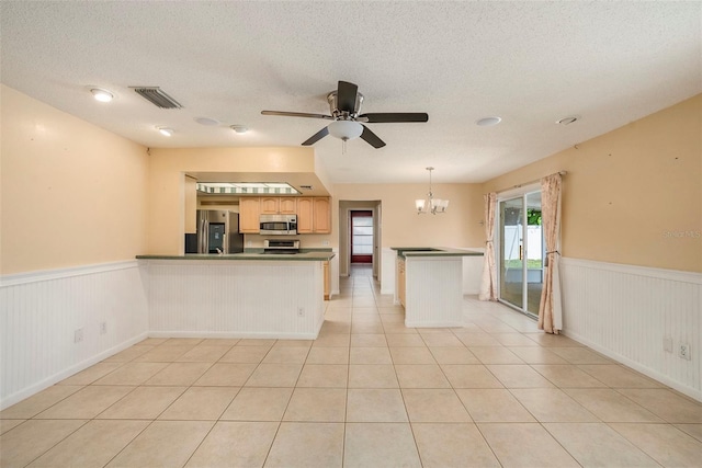 16201 Country Crossing Dr, Tampa, FL 33624 - kitchen with appliances with stainless steel finishes, a wainscoted wall, a peninsula, ceiling fan, and a chandelier