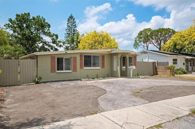 1858 Oregon Ave NE, Saint Petersburg, FL 33703 - ranch-style home featuring a gate, stucco siding, fence, and asphalt driveway