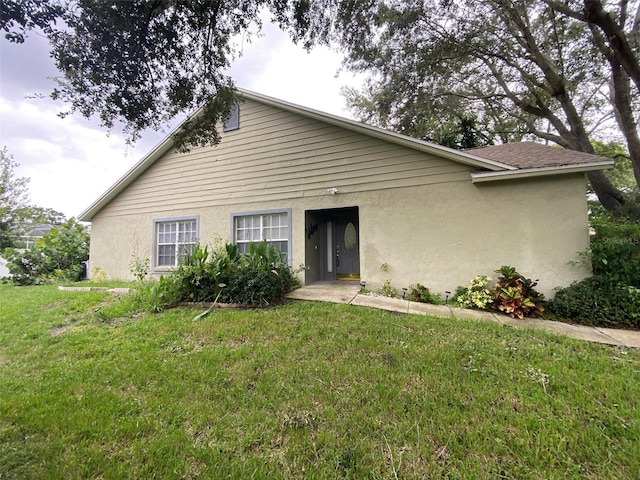 2390 Bentley Dr, Palm Harbor, FL 34684 - bungalow-style home with a front yard and stucco siding