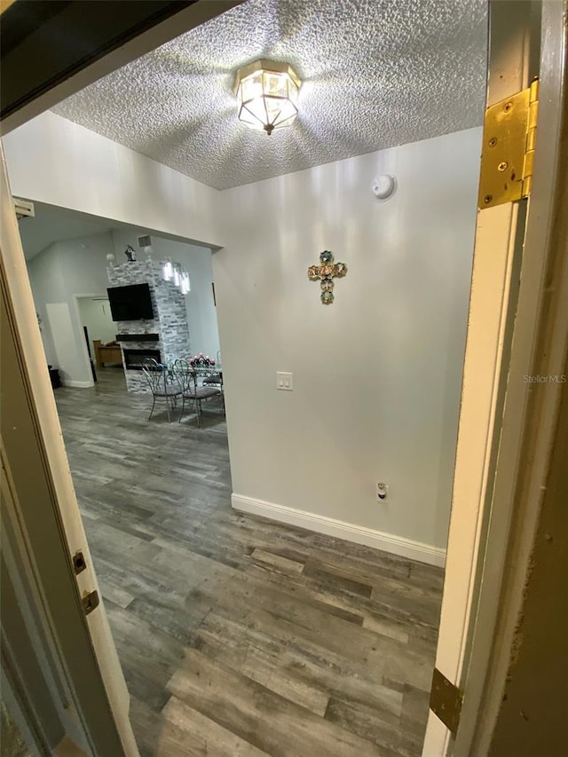 2390 Bentley Dr, Palm Harbor, FL 34684 - corridor featuring a textured ceiling, wood finished floors, and baseboards