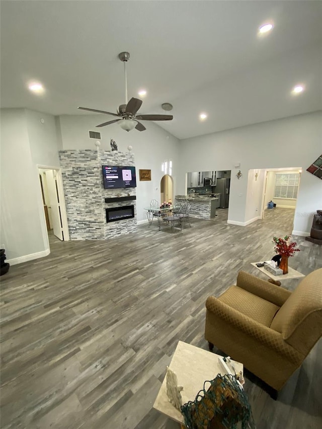 2390 Bentley Dr, Palm Harbor, FL 34684 - living area with a glass covered fireplace, a ceiling fan, baseboards, wood finished floors, and lofted ceiling