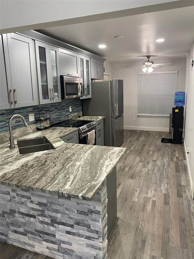 2390 Bentley Dr, Palm Harbor, FL 34684 - kitchen with stainless steel appliances, a sink, light stone counters, dark wood-style floors, and recessed lighting