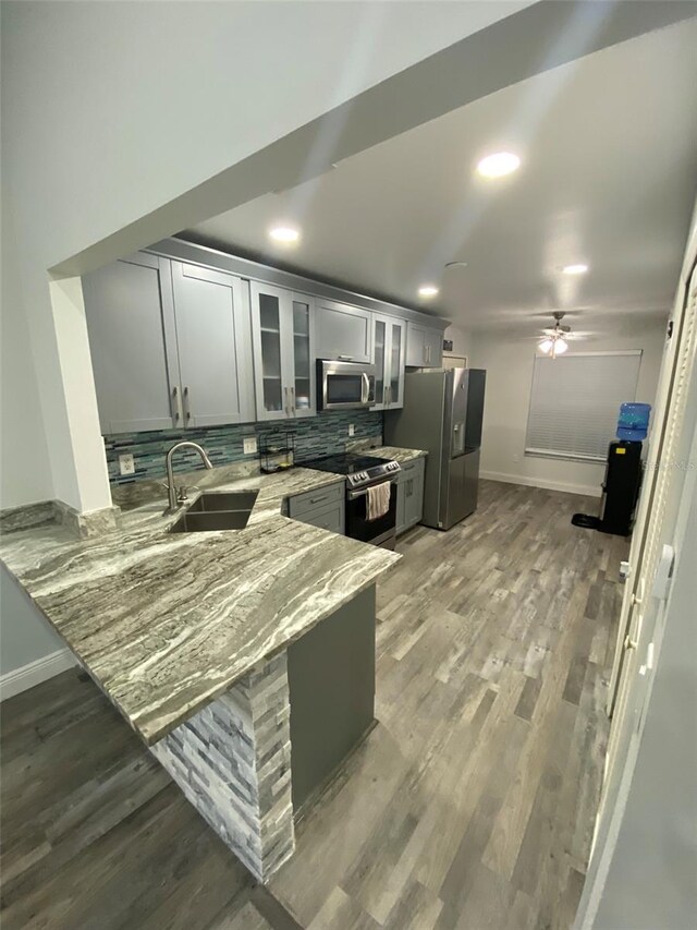 2390 Bentley Dr, Palm Harbor, FL 34684 - kitchen with appliances with stainless steel finishes, a sink, baseboards, light stone countertops, and recessed lighting