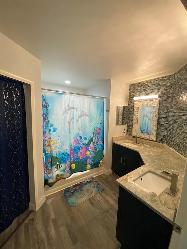 2390 Bentley Dr, Palm Harbor, FL 34684 - full bathroom with wood finished floors, shower / bath combo with shower curtain, vanity, baseboards, and recessed lighting