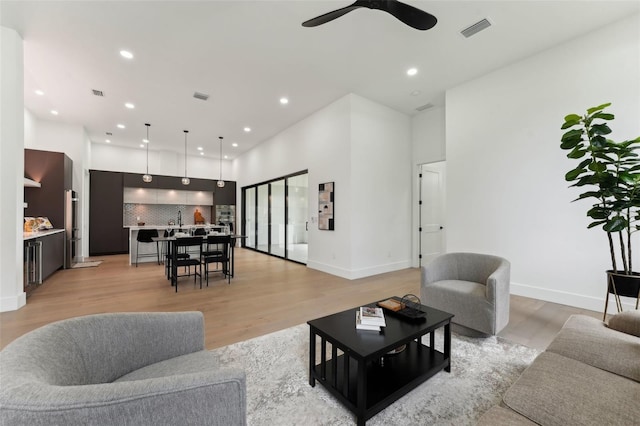 3817 W San Nicholas St, Tampa, FL 33629 - living room featuring a ceiling fan, light wood-type flooring, recessed lighting, baseboards, and a towering ceiling