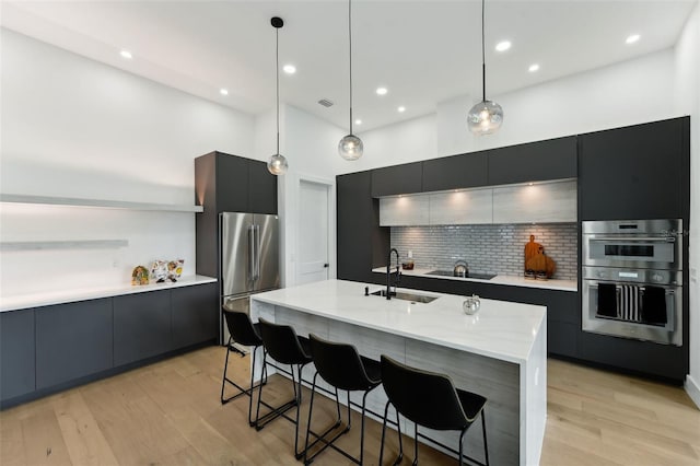 3817 W San Nicholas St, Tampa, FL 33629 - kitchen featuring appliances with stainless steel finishes, a sink, modern cabinets, tasteful backsplash, and a kitchen bar