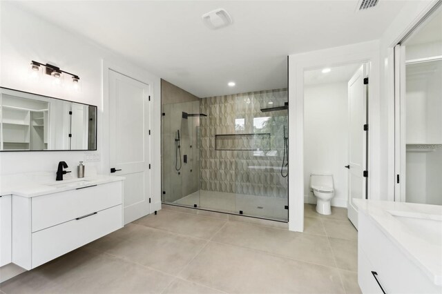 3817 W San Nicholas St, Tampa, FL 33629 - full bath featuring two vanities, a shower stall, tile patterned flooring, a walk in closet, and recessed lighting