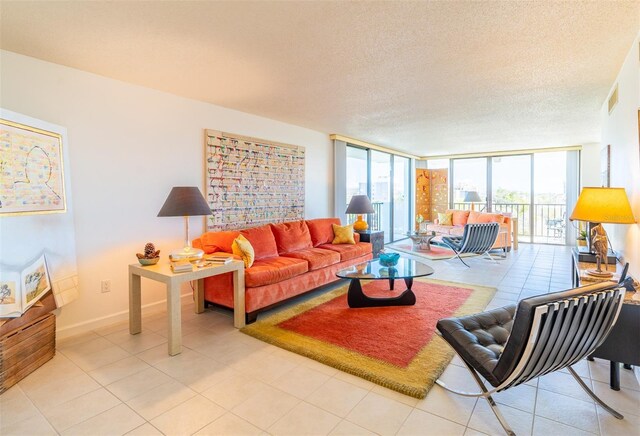 80 Rogers St Unit 6D, Clearwater, FL 33756 - living room featuring floor to ceiling windows, a textured ceiling, baseboards, and light tile patterned flooring