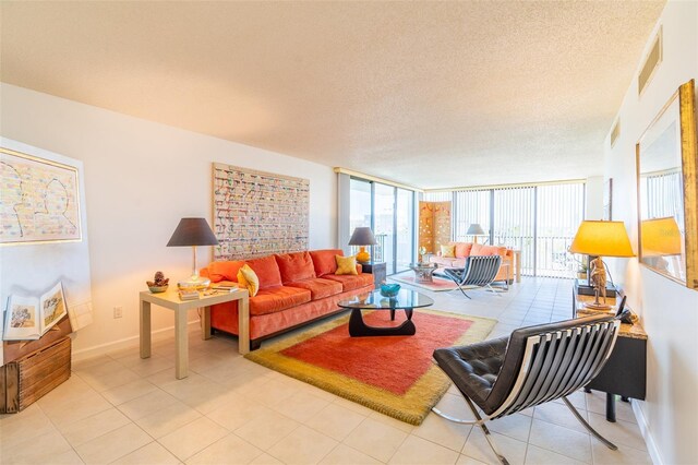 80 Rogers St Unit 6D, Clearwater, FL 33756 - living area with healthy amount of natural light, baseboards, a textured ceiling, light tile patterned floors, and floor to ceiling windows