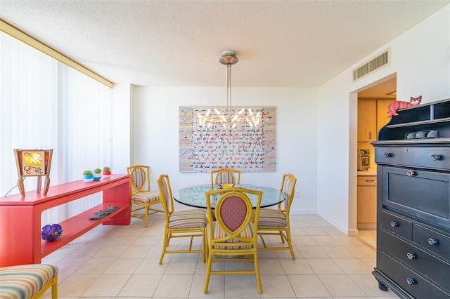 80 Rogers St Unit 6D, Clearwater, FL 33756 - dining area with a chandelier, a textured ceiling, light tile patterned floors, and baseboards