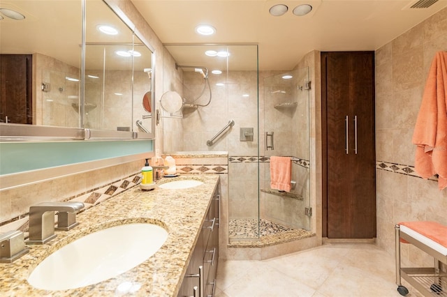 80 Rogers St Unit 6D, Clearwater, FL 33756 - bathroom featuring tile walls, tile patterned floors, a shower stall, double vanity, and recessed lighting
