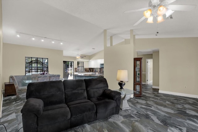 8737 Beaver Ln, Port Richey, FL 34668 - living room with a ceiling fan, vaulted ceiling, dark marble finish flooring, track lighting, and baseboards