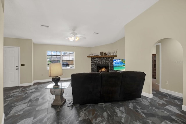 8737 Beaver Ln, Port Richey, FL 34668 - living room featuring ceiling fan, arched walkways, marble look tiles, and a fireplace