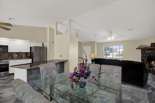 8737 Beaver Ln, Port Richey, FL 34668 - dining room with a ceiling fan, a fireplace, and lofted ceiling