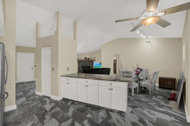 8737 Beaver Ln, Port Richey, FL 34668 - kitchen with lofted ceiling, ceiling fan, white cabinetry, freestanding refrigerator, and a peninsula
