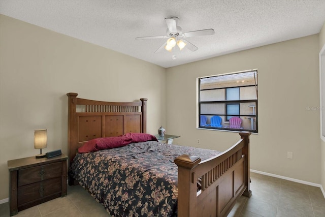 8737 Beaver Ln, Port Richey, FL 34668 - bedroom featuring baseboards, light tile patterned floors, a ceiling fan, and a textured ceiling