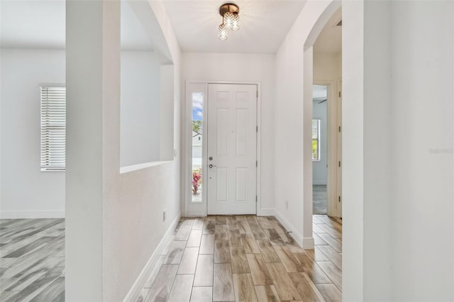 12710 Wheatgrass Ct, Parrish, FL 34219 - entrance foyer with arched walkways, light wood finished floors, and baseboards