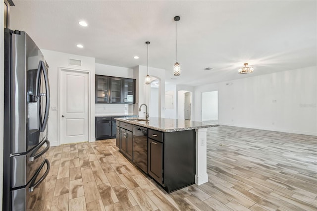 12710 Wheatgrass Ct, Parrish, FL 34219 - kitchen with stainless steel fridge, a sink, dishwasher, light wood-type flooring, and arched walkways