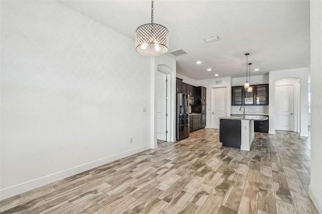 12710 Wheatgrass Ct, Parrish, FL 34219 - kitchen with stainless steel fridge with ice dispenser, light wood finished floors, a sink, baseboards, and recessed lighting