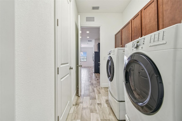 12710 Wheatgrass Ct, Parrish, FL 34219 - laundry room featuring separate washer and dryer and cabinet space