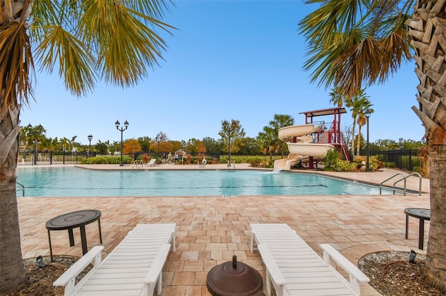 12710 Wheatgrass Ct, Parrish, FL 34219 - community pool featuring a water slide, fence, and a patio