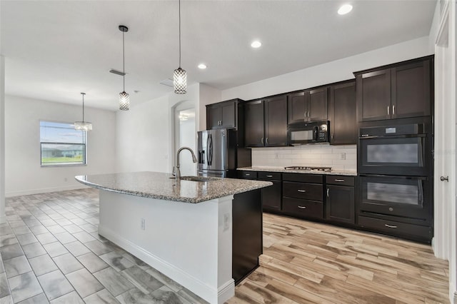 12710 Wheatgrass Ct, Parrish, FL 34219 - kitchen featuring black appliances, a sink, backsplash, light stone counters, and recessed lighting
