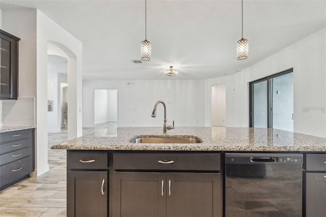 12710 Wheatgrass Ct, Parrish, FL 34219 - kitchen featuring black dishwasher, a sink, arched walkways, and decorative light fixtures