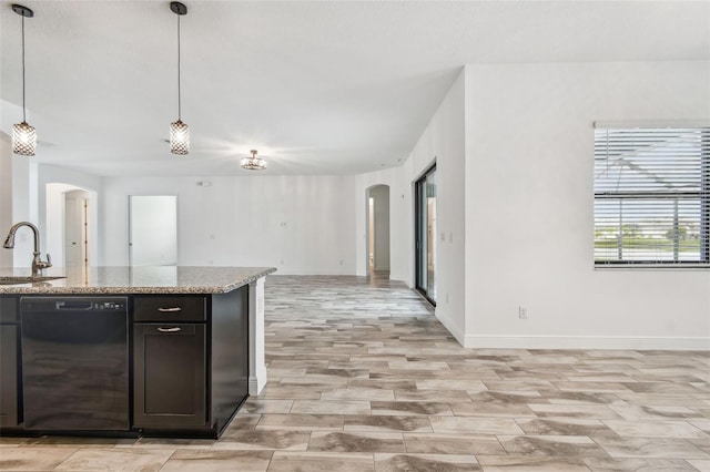 12710 Wheatgrass Ct, Parrish, FL 34219 - kitchen featuring arched walkways, dishwasher, open floor plan, a sink, and baseboards