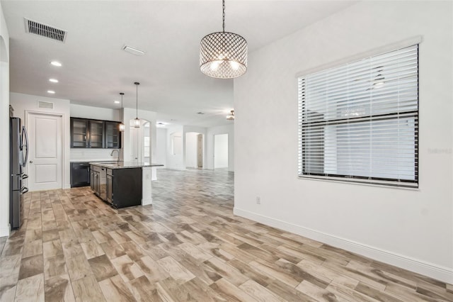 12710 Wheatgrass Ct, Parrish, FL 34219 - kitchen featuring open floor plan, freestanding refrigerator, light wood-style flooring, a sink, and recessed lighting