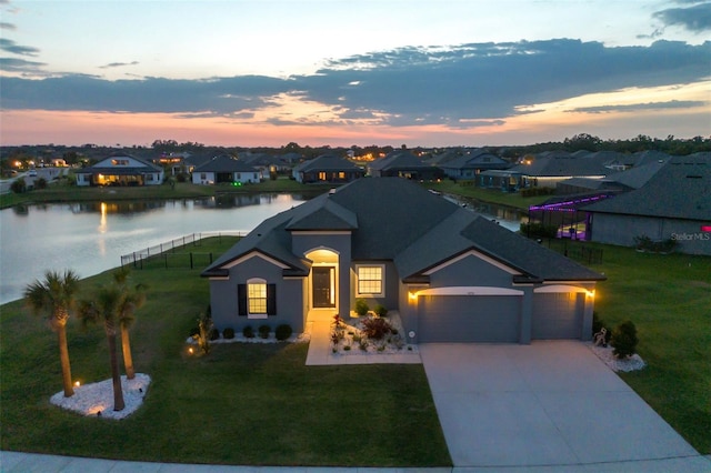 12710 Wheatgrass Ct, Parrish, FL 34219 - view of front of house with a garage, a residential view, driveway, a water view, and stucco siding